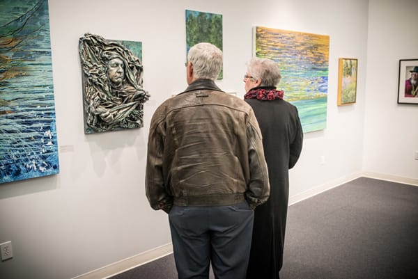 Man and woman viewing artwork on the gallery wall